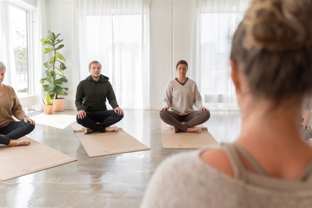 Deltagere sidder i meditation under et yogahold i Silkeborg.